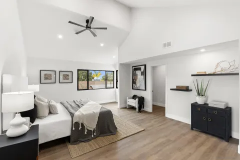 a bedroom with a large bed and a chandelier