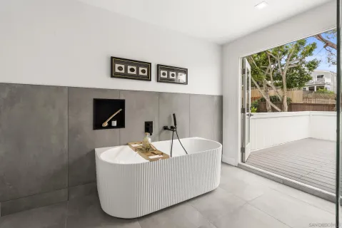 a living room with furniture a flat screen tv and a view of bathroom
