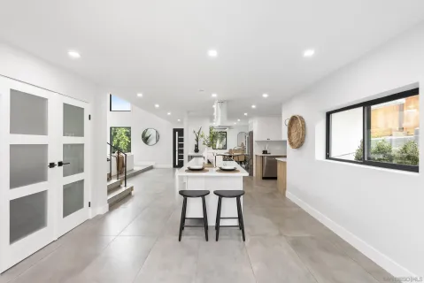 a kitchen with a sink and chairs