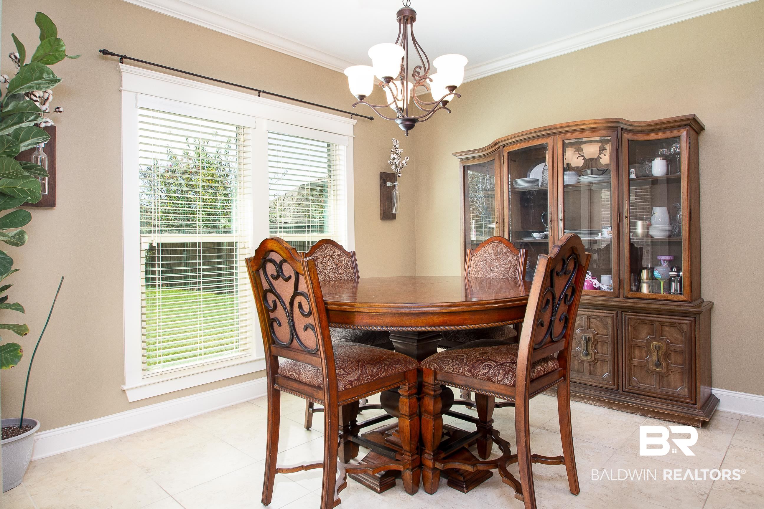 8625 Rosedown Lane Daphne, AL 36526 - Photo 11 of 29 Dining room with an inviting chandelier, ornamental molding, and light tile patterned flooring