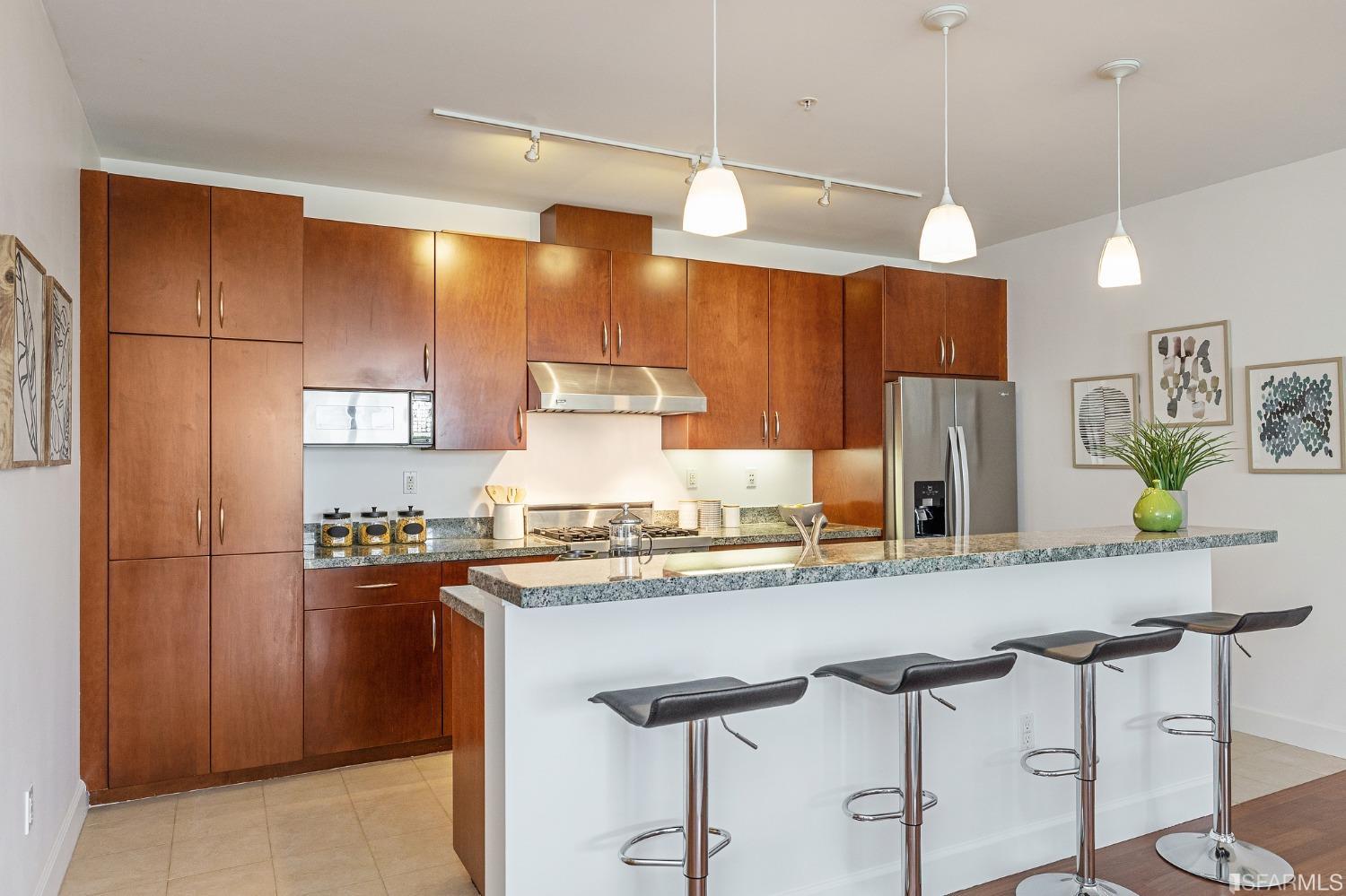 741 Clement Street, Unit 202 San Francisco, CA 94118 - Photo 9 of 23 a kitchen with stainless steel appliances granite countertop a sink and a refrigerator