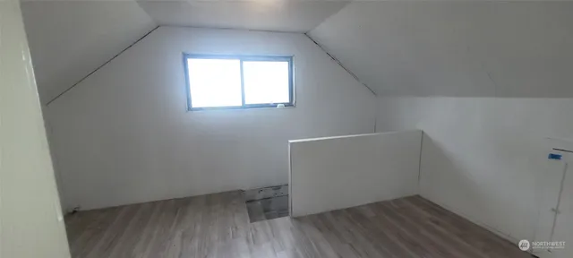 a view of a small space with wooden floor and a window