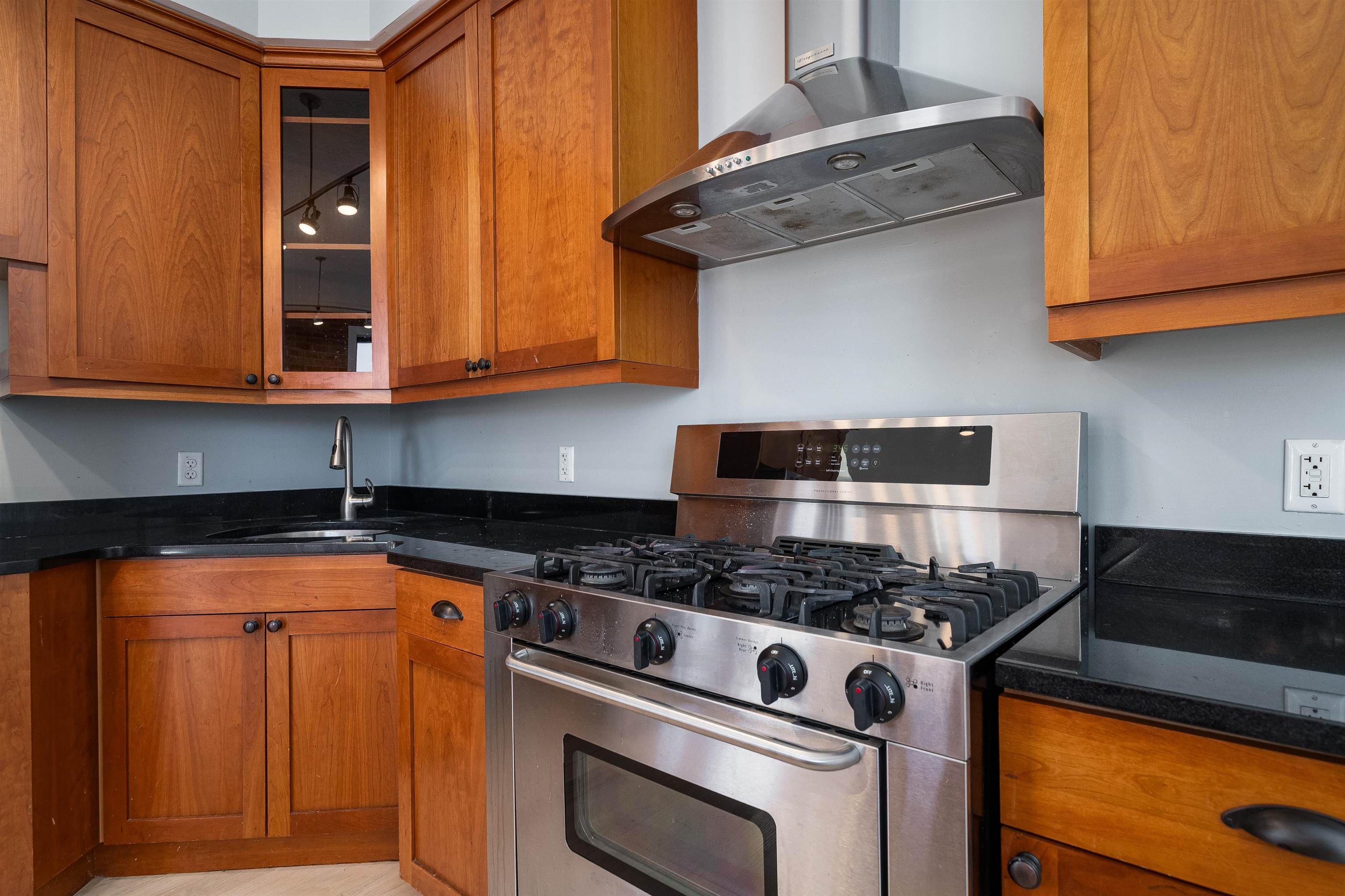 100 Paterson Plank Road, Unit 504 Jersey City, NJ 07307 - Photo 11 of 23 a kitchen with granite countertop wood cabinets and stainless steel appliances