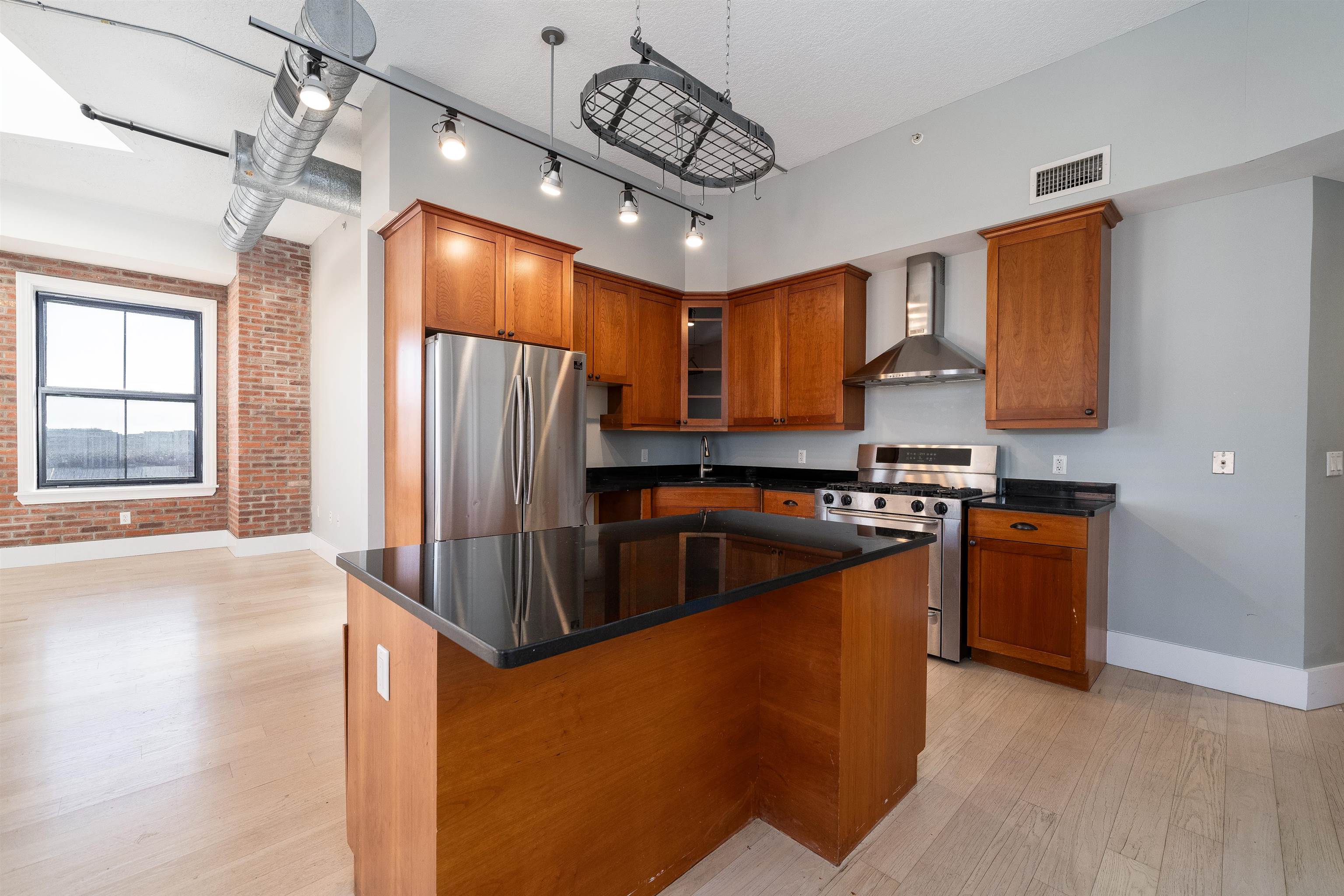 100 Paterson Plank Road, Unit 504 Jersey City, NJ 07307 - Photo 8 of 23 a kitchen with stainless steel appliances granite countertop a refrigerator a sink dishwasher a stove and a refrigerator with wooden floor