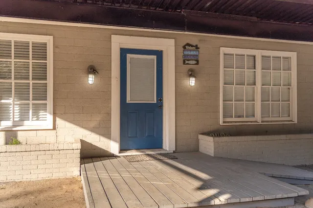 a view of a hallway with wooden floor and a living room