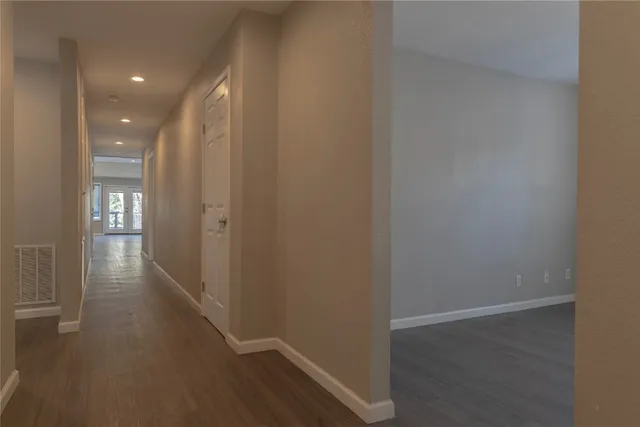 a view of a hallway with wooden floor