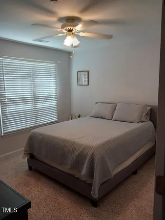 a bedroom with a bed chandelier and a window