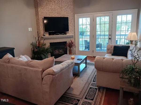 a living room with furniture a flat screen tv and a fireplace