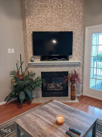 a living room with furniture a flat screen tv and a fireplace