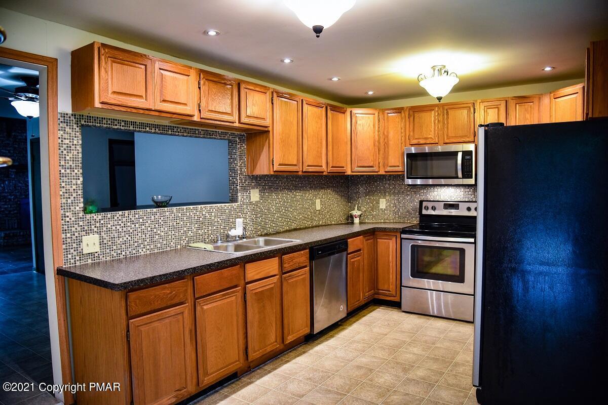 2202 Delaware Court East Bushkill, PA 18324 - Photo 4 of 18 a kitchen with stainless steel appliances granite countertop a stove a sink and a microwave