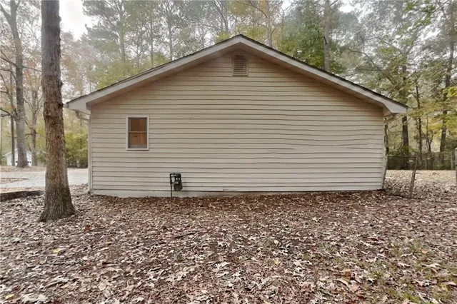 a white house sitting in middle of the forest
