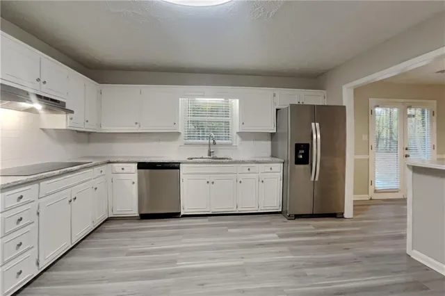 a kitchen with a refrigerator sink and cabinets