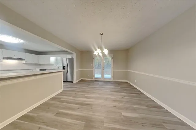 a view of an empty room with window and wooden floor