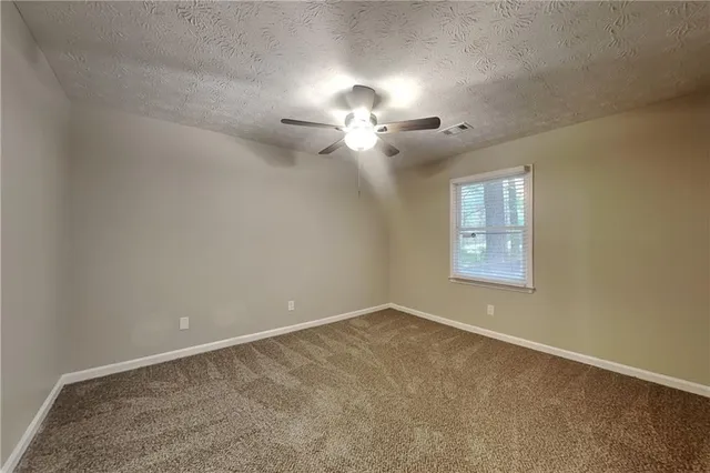 a view of a room with a ceiling fan and a window