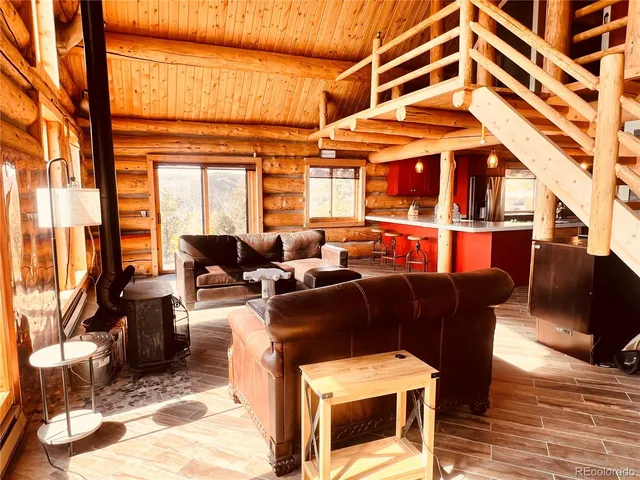 a living room with furniture a flat screen tv and floor to ceiling window