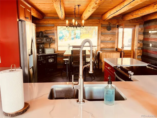 a kitchen with stainless steel appliances kitchen island granite countertop a refrigerator and a sink