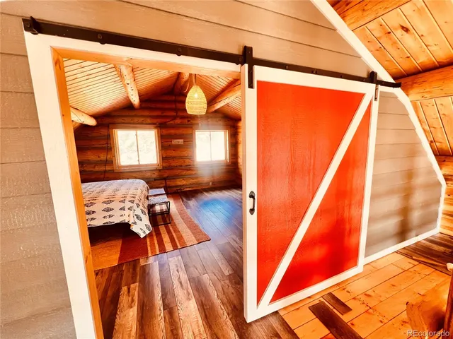 a bedroom with wooden floor and a bed