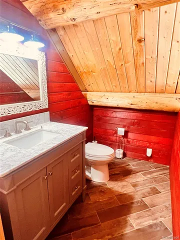 a bathroom with a toilet a sink and mirror