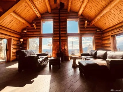 a living room with furniture fireplace and large windows