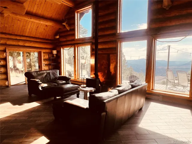 a living room with couches a dining table and chairs with wooden floor