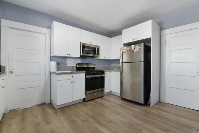 a kitchen with a refrigerator stove and white cabinets