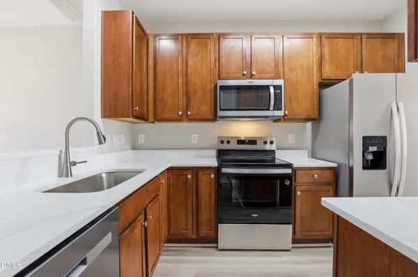 a kitchen with stainless steel appliances a stove a sink a refrigerator and cabinets