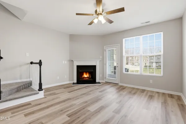 a view of empty room with a fireplace and wooden floor