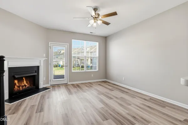 a view of an empty room with window and fire place