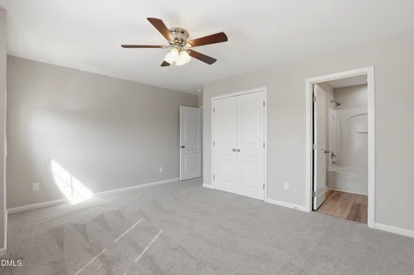 a view of a big room with closet and a chandelier fan