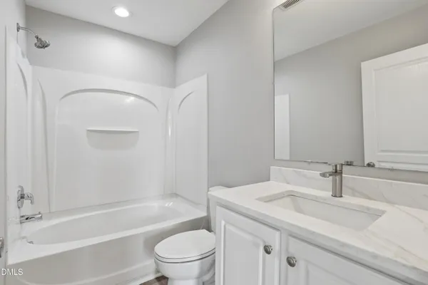 a bathroom with a granite countertop sink a toilet and shower