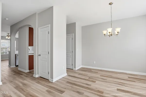a view of a chandelier in big room with wooden floor