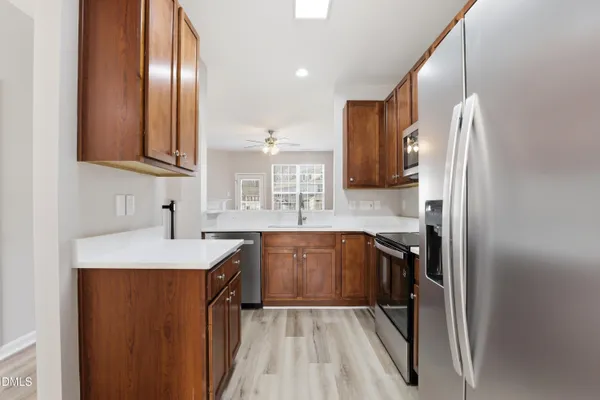 a kitchen with stainless steel appliances granite countertop a sink stove and refrigerator