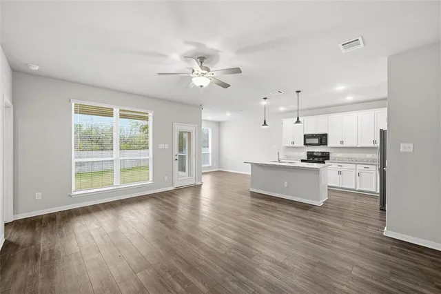 a view of kitchen with refrigerator and wooden floor