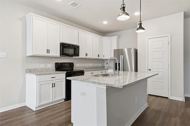 a view of kitchen with granite countertop cabinets and stainless steel appliances
