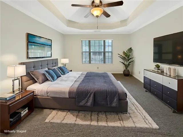 a spacious bedroom with a bed and a flat screen tv