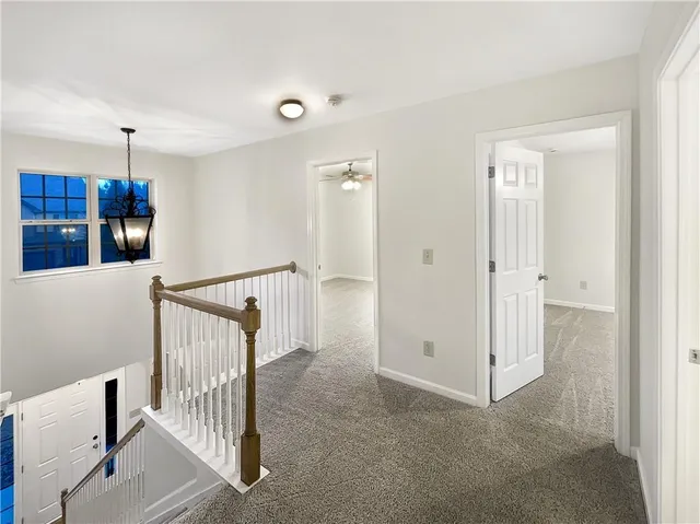 a view of a hallway with entryway and stairs