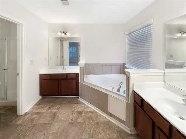 a bathroom with a tub sink and mirror