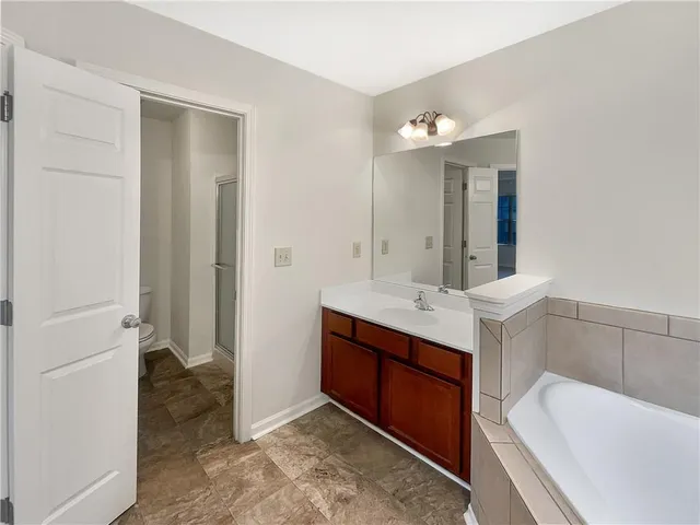 a bathroom with a tub sink and mirror