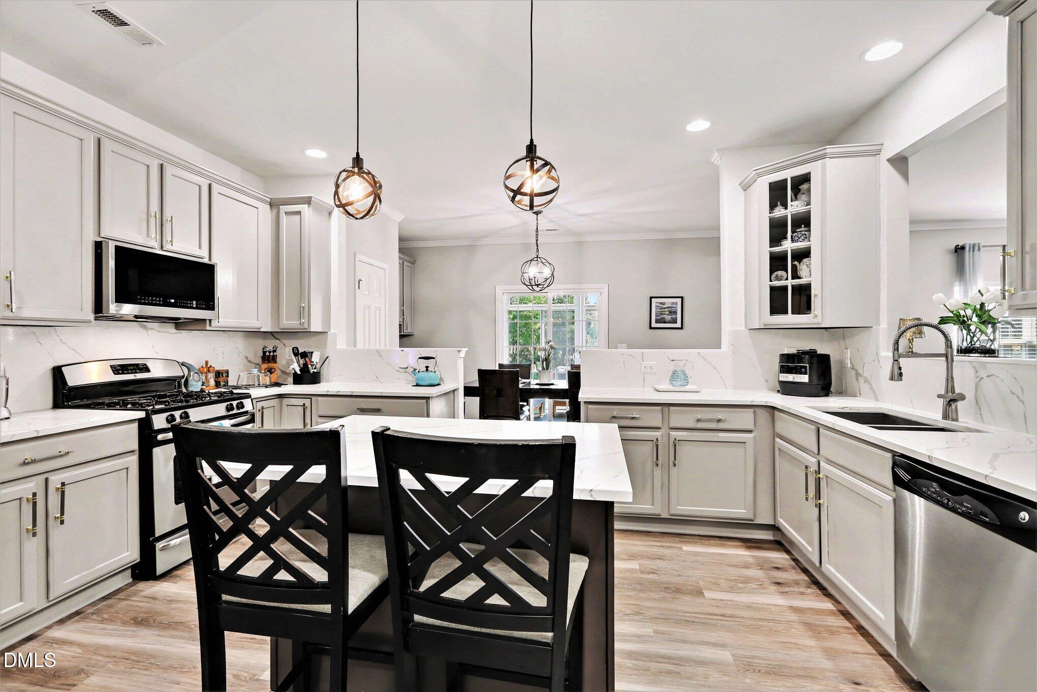 437 Field Glow Lane Apex, NC 27539 - Photo 18 of 48 a kitchen with white cabinets and chairs