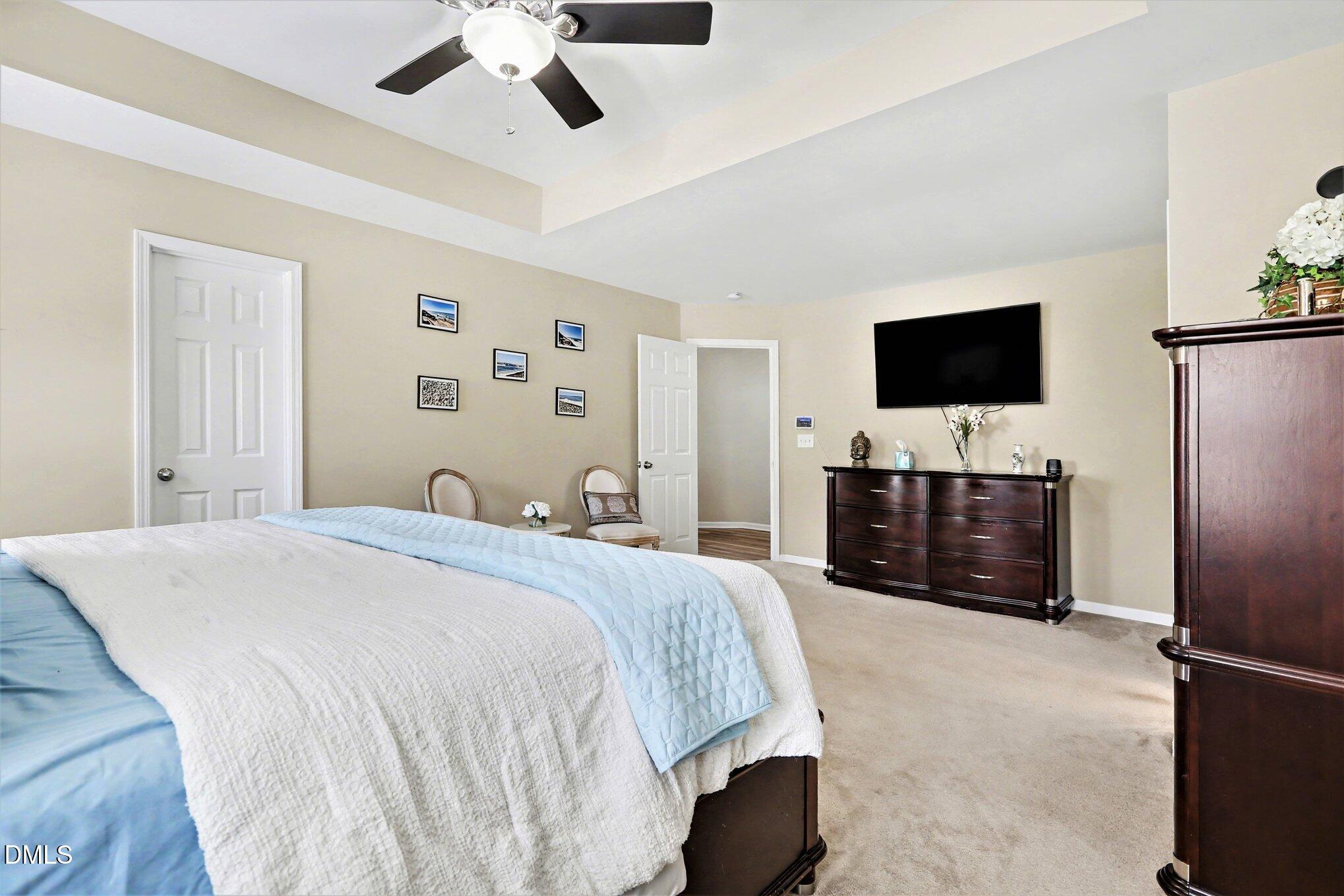 437 Field Glow Lane Apex, NC 27539 - Photo 24 of 48 a bedroom with a bed and a flat screen tv