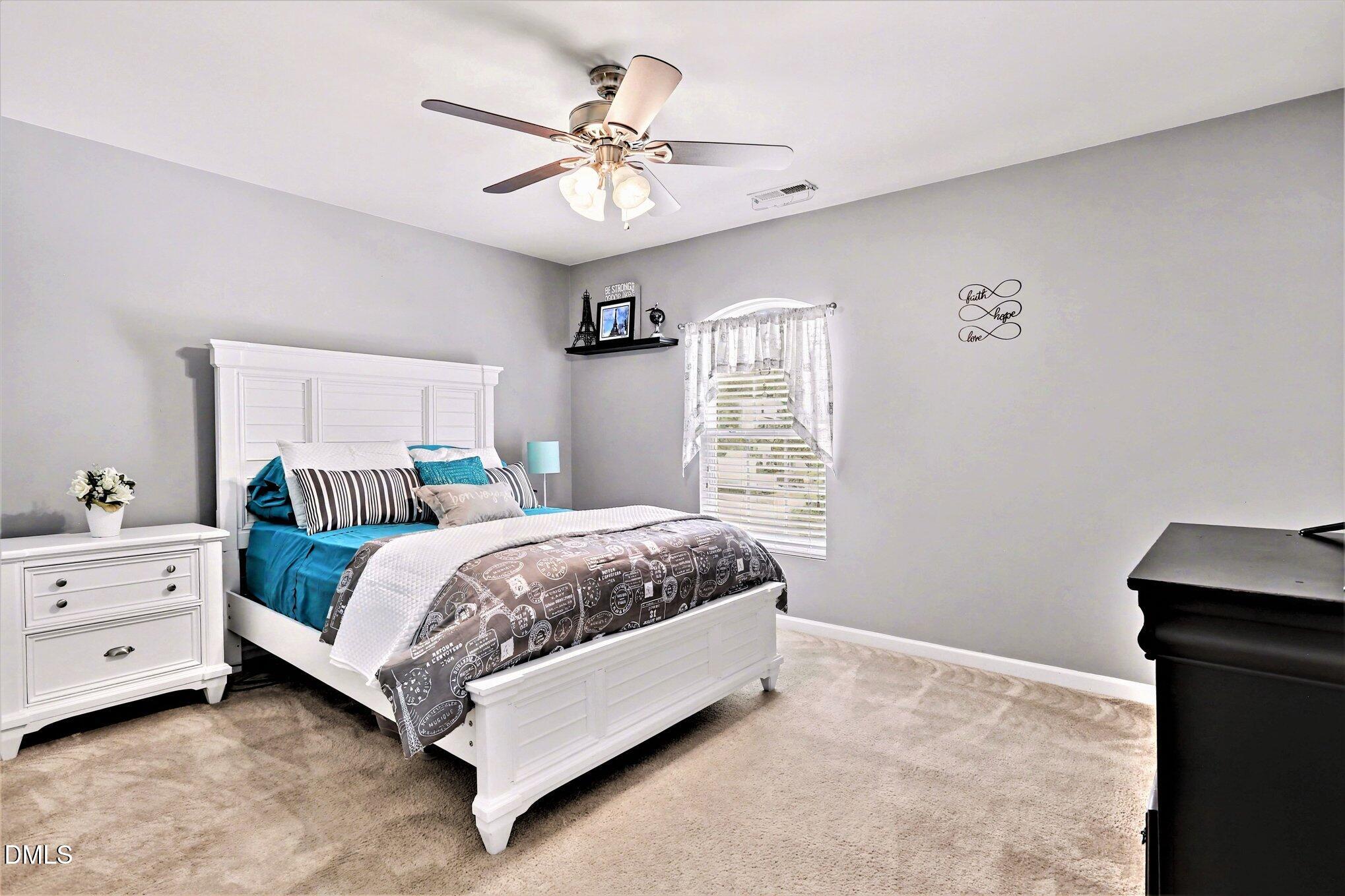 437 Field Glow Lane Apex, NC 27539 - Photo 26 of 48 a spacious bedroom with a bed and a chandelier