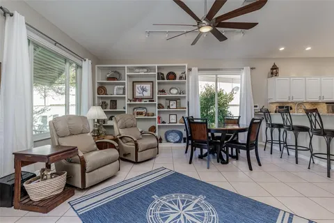 a living room with furniture a bookshelf and a window