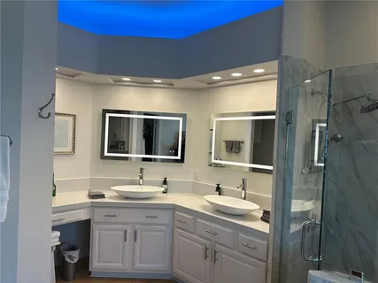 a spacious bathroom with double vanity sink a mirror and a shower