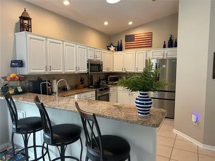 a kitchen with granite countertop a sink stove and refrigerator