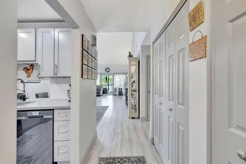 a view of hallway with cabinets and wooden floor
