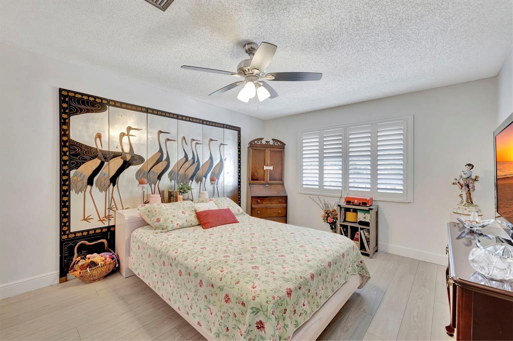 8799 Holly Court, Unit 202 Tamarac, FL 33321 - Photo 21 of 26 a bedroom with a bed and a closet