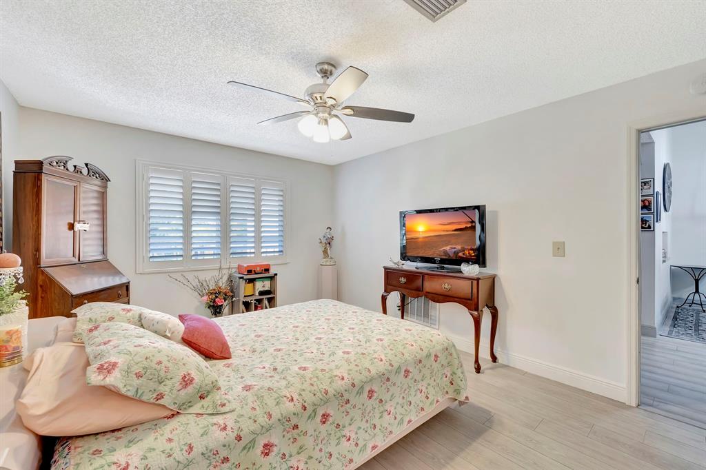 8799 Holly Court, Unit 202 Tamarac, FL 33321 - Photo 22 of 26 a bedroom with a bed and a flat screen tv