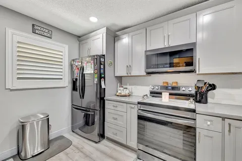 a kitchen with stainless steel appliances granite countertop a refrigerator sink and stove