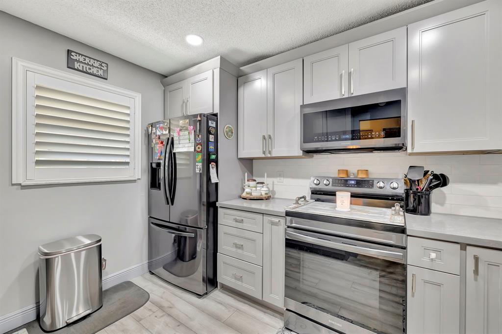 8799 Holly Court, Unit 202 Tamarac, FL 33321 - Photo 6 of 26 a kitchen with stainless steel appliances granite countertop a refrigerator sink and stove