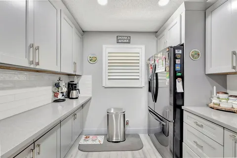 a kitchen with stainless steel appliances granite countertop a refrigerator and a sink
